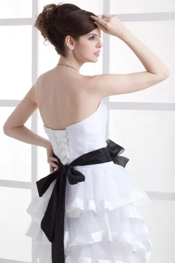 Robe de soirée blanche avec ceinture noire orné de fleur à volants